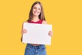 Young beautiful blonde woman holding blank empty banner looking positive and happy standing and smiling with a confident smile Royalty Free Stock Photo