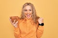 Young beautiful blonde woman holding bowl with healthy almonds over yellow background screaming proud, celebrating victory and Royalty Free Stock Photo