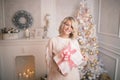 Young beautiful blonde woman holding a gift box. Christmas and new year concept. Royalty Free Stock Photo