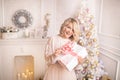 Young beautiful blonde woman holding a gift box. Christmas and new year concept