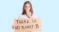 Young beautiful blonde woman holding there is no planet b banner covering mouth with hand, shocked and afraid for mistake Royalty Free Stock Photo