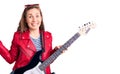 Young beautiful blonde woman playing electric guitar celebrating victory with happy smile and winner expression with raised hands Royalty Free Stock Photo