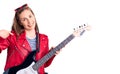 Young beautiful blonde woman playing electric guitar pointing finger to one self smiling happy and proud Royalty Free Stock Photo