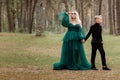 Young beautiful blonde woman queen with young boy in black outfit. Princess mother walks with son. autumn green forest mystic. Royalty Free Stock Photo