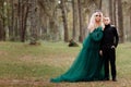 Young beautiful blonde woman queen with young boy in black outfit. Princess mother walks with son. autumn green forest mystic. Royalty Free Stock Photo