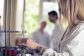 Young beautiful blonde woman researcher chemist preparing substances for chemical use with laboratory dishes.Pharmacist making ch