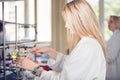 Young beautiful blonde woman researcher chemist preparing substances for chemical use with laboratory dishes.Pharmacist making ch Royalty Free Stock Photo