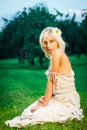 Young beautiful blonde woman sitting on grass Royalty Free Stock Photo