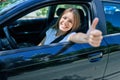 Young beautiful blonde woman smiling happy with thumb up doing ok sign sitting at the car Royalty Free Stock Photo