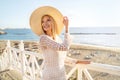 Young beautiful blonde woman on vacation , walking on the coast wearing summer hat, smiling happy Royalty Free Stock Photo