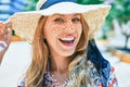 Young beautiful blonde woman on vacation wearing summer hat smiling happy Royalty Free Stock Photo