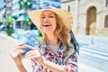 Young beautiful blonde woman on vacation wearing summer hat smiling happy Royalty Free Stock Photo