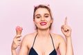 Young beautiful blonde woman wearing bikini holding ice cream surprised with an idea or question pointing finger with happy face, Royalty Free Stock Photo