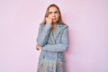 Young beautiful blonde woman wearing business jacket serious face thinking about question with hand on chin, thoughtful about Royalty Free Stock Photo