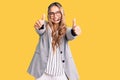 Young beautiful blonde woman wearing call center agent headset approving doing positive gesture with hand, thumbs up smiling and Royalty Free Stock Photo