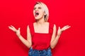 Young beautiful blonde woman wearing casual clothes crazy and mad shouting and yelling with aggressive expression and arms raised Royalty Free Stock Photo