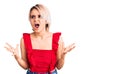 Young beautiful blonde woman wearing casual clothes crazy and mad shouting and yelling with aggressive expression and arms raised Royalty Free Stock Photo