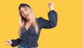 Young beautiful blonde woman wearing casual clothes dancing happy and cheerful, smiling moving casual and confident listening to Royalty Free Stock Photo