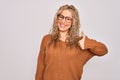 Young beautiful blonde woman wearing casual sweater and glasses over white background doing happy thumbs up gesture with hand Royalty Free Stock Photo