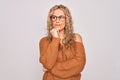 Young beautiful blonde woman wearing casual sweater and glasses over white background with hand on chin thinking about question, Royalty Free Stock Photo