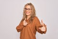 Young beautiful blonde woman wearing casual sweater and glasses over white background pointing fingers to camera with happy and Royalty Free Stock Photo