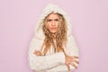 Young beautiful blonde woman wearing casual sweater with hood over isolated pink background skeptic and nervous, disapproving Royalty Free Stock Photo