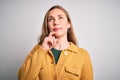 Young beautiful blonde woman wearing casual sweater over isolated white background with hand on chin thinking about question, Royalty Free Stock Photo