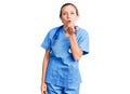 Young beautiful blonde woman wearing doctor uniform and stethoscope looking at the camera blowing a kiss with hand on air being Royalty Free Stock Photo