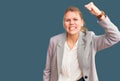 Young beautiful blonde woman wearing elegant jacket angry and mad raising fist frustrated and furious while shouting with anger Royalty Free Stock Photo