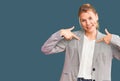 Young beautiful blonde woman wearing elegant jacket looking confident with smile on face, pointing oneself with fingers proud and Royalty Free Stock Photo