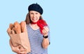 Young beautiful blonde woman wearing french beret holding bag with bread annoyed and frustrated shouting with anger, yelling crazy Royalty Free Stock Photo