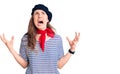 Young beautiful blonde woman wearing french beret and striped t-shirt crazy and mad shouting and yelling with aggressive Royalty Free Stock Photo