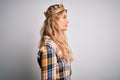 Young beautiful blonde woman wearing golden crown of queen over isolated white background looking to side, relax profile pose with Royalty Free Stock Photo