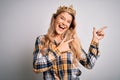 Young beautiful blonde woman wearing golden crown of queen over isolated white background smiling and looking at the camera Royalty Free Stock Photo