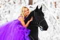 Young woman in long dress riding a horse in winter Royalty Free Stock Photo