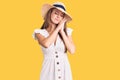 Young beautiful blonde woman wearing summer dress and hat sleeping tired dreaming and posing with hands together while smiling Royalty Free Stock Photo