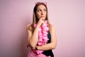 Young beautiful blonde woman wearing swimsuit and floral Hawaiian lei over pink background with hand on chin thinking about Royalty Free Stock Photo
