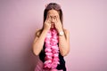 Young beautiful blonde woman wearing swimsuit and floral Hawaiian lei over pink background rubbing eyes for fatigue and headache, Royalty Free Stock Photo