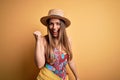 Young beautiful blonde woman wearing swimsuit and summer hat over yellow background Dancing happy and cheerful, smiling moving Royalty Free Stock Photo