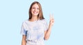 Young beautiful blonde woman wearing tye die tshirt smiling with happy face winking at the camera doing victory sign Royalty Free Stock Photo