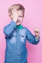 Young beautiful boy with blue shirt and butterfly tie. Studio portrait over pink background. Royalty Free Stock Photo