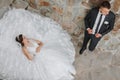 a young beautiful bride with blue eyes in a wedding dress, lying on stone steps Royalty Free Stock Photo