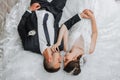 a young beautiful bride with blue eyes in a wedding dress, lying on stone steps Royalty Free Stock Photo