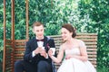 Young beautiful bride and groom drinking coffee at the outdoors cafe . Happy wedding day Royalty Free Stock Photo