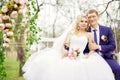 Young and beautiful bride and groom sitting on a white swing in Royalty Free Stock Photo