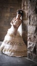 Young beautiful bride leaning against stone pillar Royalty Free Stock Photo