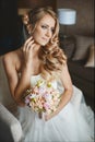 Young and beautiful bride, sensual blond model girl with gentle makeup and with wedding hairstyle in the white dress Royalty Free Stock Photo