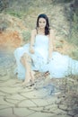 Young beautiful bride sitting in desert Royalty Free Stock Photo