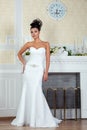 Young beautiful bride standing near fireplace