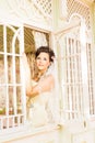 Young beautiful bride waits for groom near the window. Beautiful Bride lit by sunlight. beautiful young bride waiting